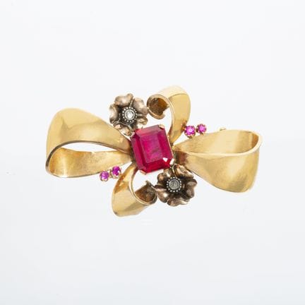 18K yellow gold bow-shaped brooch with a ruby-colo