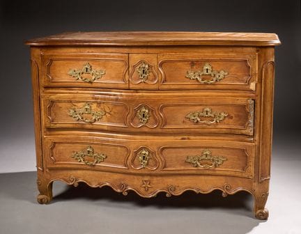 Cómoda de formas curvas, de madera de nogal moldea