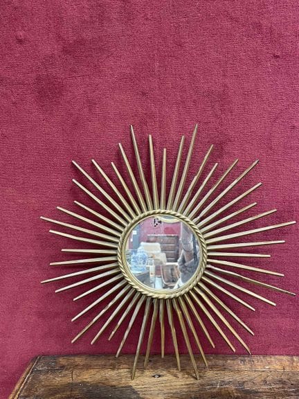 Miroir en métal doré à décor rayonant 
Dans le gou