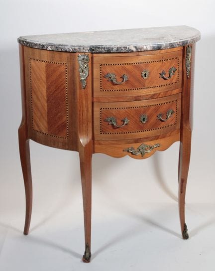 A half-moon chest of drawers made of wood veneer a