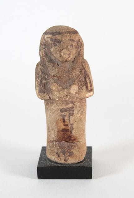 Ushabti.
Eroded siliceous faience; dark pigment.
E