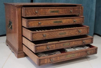 A wooden box with five drawers containing a set of