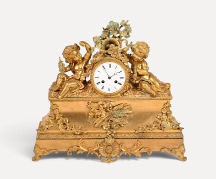 Orologio da tavolo in bronzo cesellato e dorato. I
