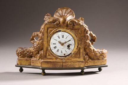 * Pendulette en bois doré et sculpté de festons et