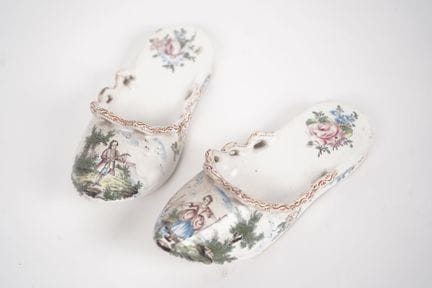 Pair of glazed ceramic shoes decorated with bucoli