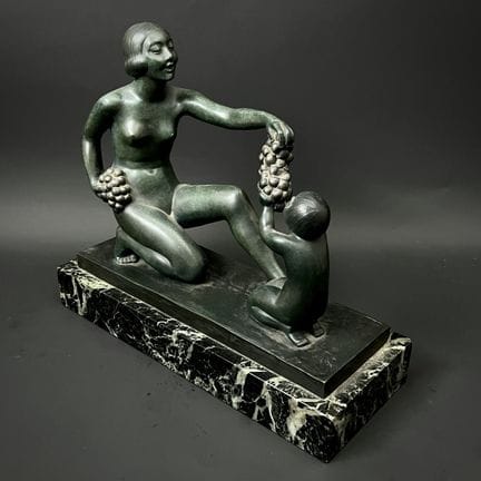 热内维耶夫·格兰热（1877-1967） 
一位妇女正将一串葡萄递给一个孩子
带绿色釉色的青铜群像
