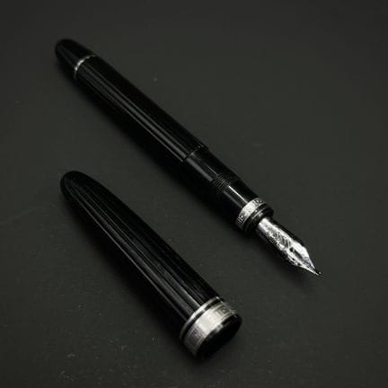 OMAS
黑色树脂材质的钢笔，笔身饰有滚花纹理，并环绕着镌刻有希腊式蜿蜒纹样的镀银的金属圈，笔尖为7