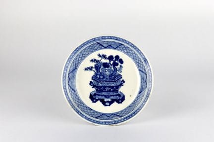 Petit plat bleu et blanc représentant une jardiniè