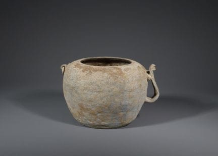 Une jarre en poterie grise à anse et à motifs en r