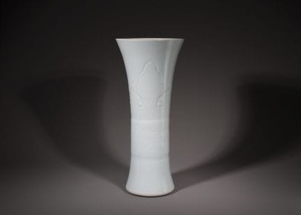 Un beau vase-gobelet en faïence blanche sculptée, 