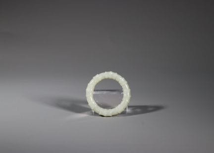 青瓷玉戒指，19/20世纪。这枚戒指采用柔和抛光、色泽淡雅且带有细微斑纹的玉石，雕刻成一圈连贯的竹节