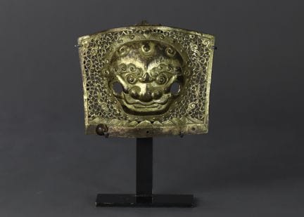 Plaque représentant un masque de lion en alliage d