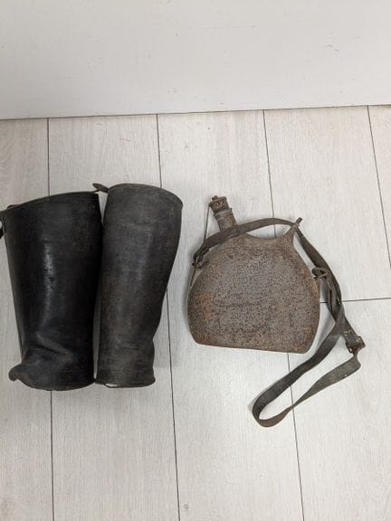 第一次世界大战。本套藏品包括一对皮质护腿（高度：27厘米）和一个金属水壶（高度：24厘米）。（有磨损