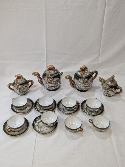 中国。一套饰有龙纹的瓷器茶具，包括3个茶壶、8个茶杯、6个茶托和一个糖罐。高度7至13厘米。（有磨损