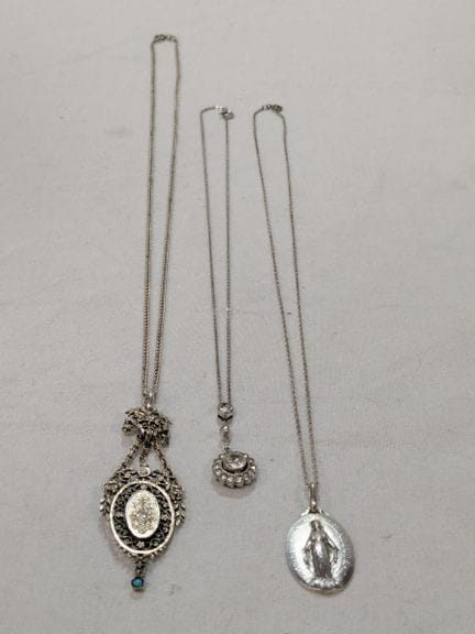 Lot de trois chaînes et leurs pendentifs en argent