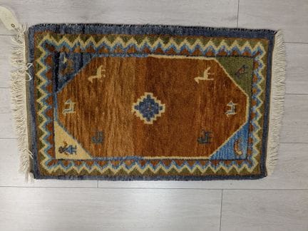 Wollteppich mit stilisierten Tiermotiven auf orang