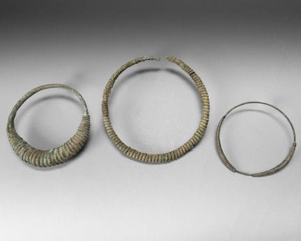 Three bronze torques with a green patina, decorate