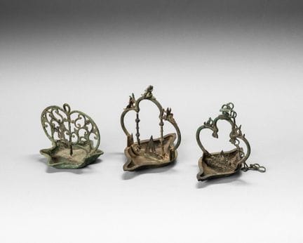 Tres lámparas de bronce, con las copas en forma de