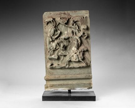 A gray sandstone stele carved in high relief with 