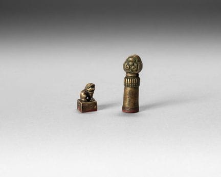 Two bronze seals:
- a cubic seal, topped by a seat
