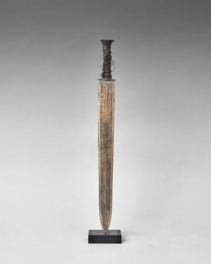 Bronze sword; the hollow hilt flares toward the en