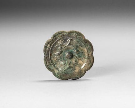A silver-plated bronze mirror with a multi-lobed d