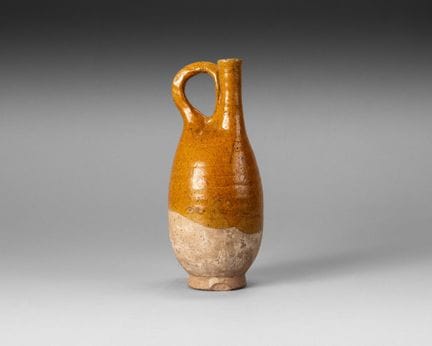 Stoneware flask with an ochre glaze; the elongated