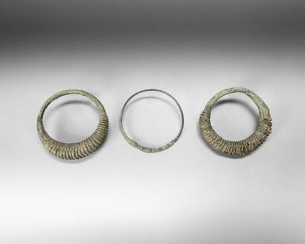 Three bronze torques with a green patina, decorate