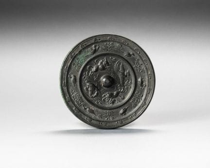 Circular bronze mirror; the mount is surrounded by