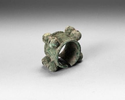 Bronze bracelet with a green patina, adorned with 