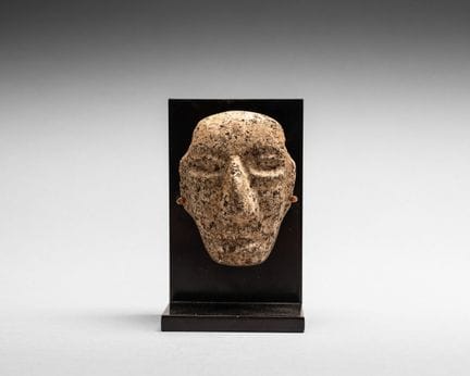 Maske als Anhänger. Das Gesicht ist oval geformt. 