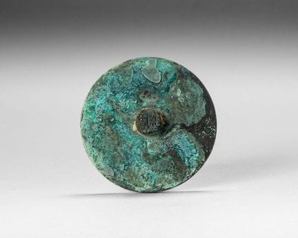 Circular bronze mirror with a green patina. There 