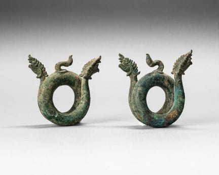 Dos brazaletes de bronce con pátina verde, con for