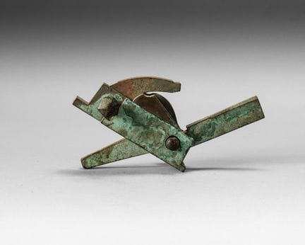Bronze crossbow trigger with a green patina. 
L. 1