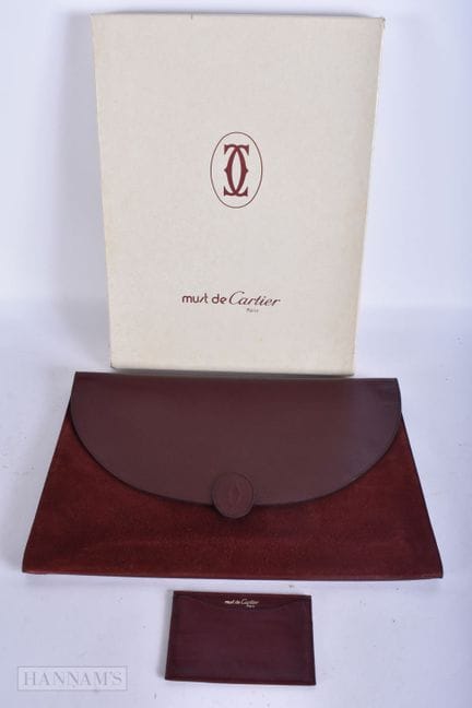 EINE UNBENUTZTE CARTIER-LEDER-CLUTCH ALS DOKUMENTE