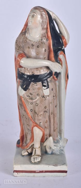 AN EARLY 19TH CENTURY STAFFORDSHIRE FIGURE OF A FE