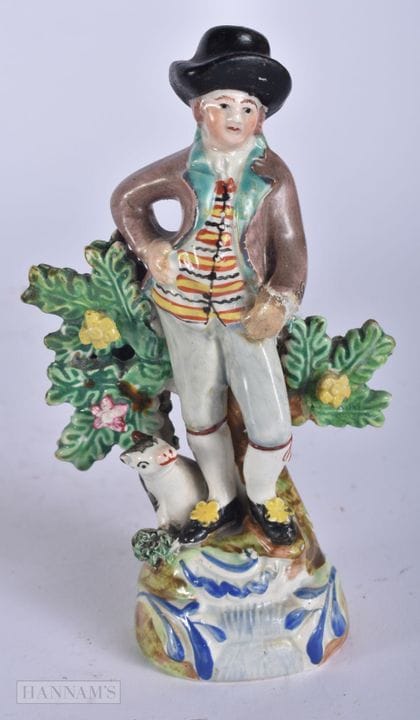 AN EARLY 19TH CENTURY STAFFORDSHIRE FIGURE OF A MA