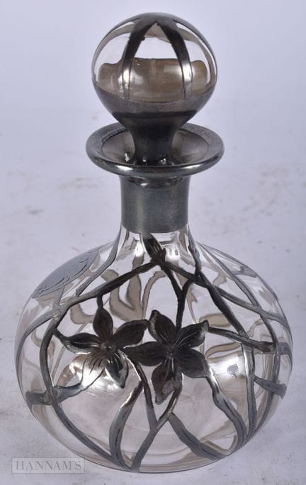 A SILVER OVERLAID GLASS SCENT BOTTLE. 15 cm high.