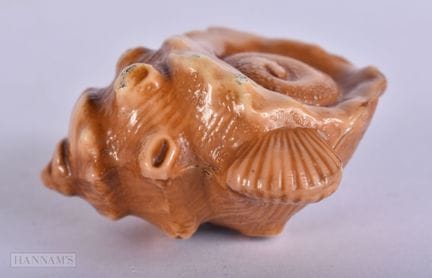 Un netsuke japonés de cerámica con forma de concha