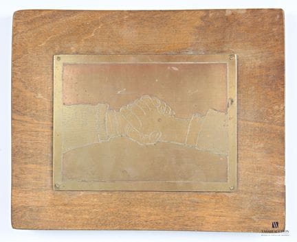 Placa grabada con el título «El apretón de manos»,