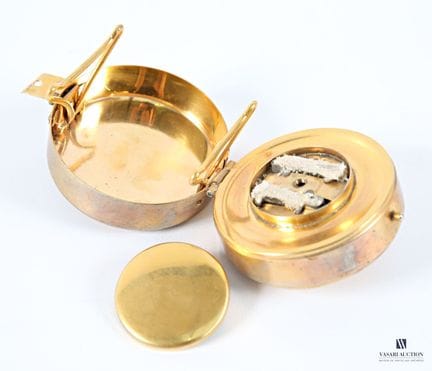 一款黄铜制成的圆柱形便携式炉具，掀开盖子可见一个炉头和一个可拆卸的支架。
（有磨损、划痕和氧化痕迹）