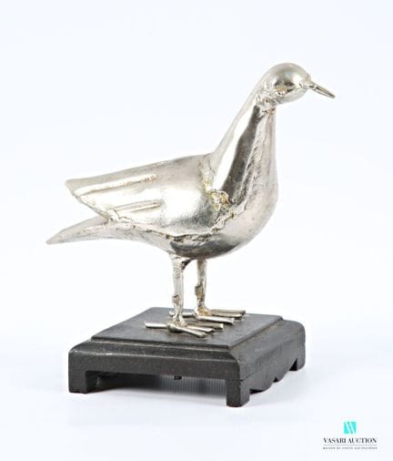 Metallskulptur in Form eines Vogels.
Sockel aus ge