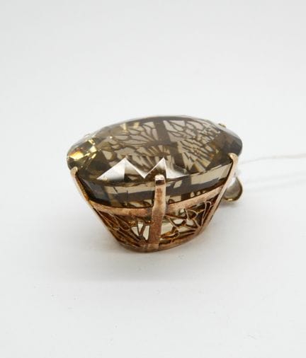Pendentif en métal doré formé d'une résille tenant