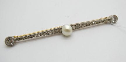Broche en or jaune et gris ornée d'une perle centr