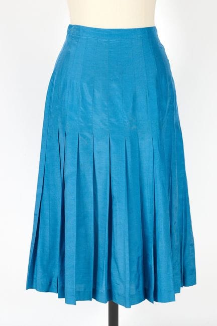 SCHIAPARELLI. 
Falda azul plisada de largo medio.
