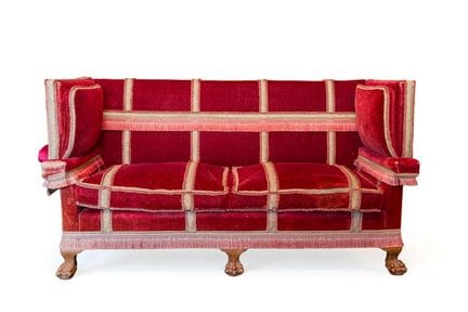 Canapé recouvert de velours rouge à franges, avec 
