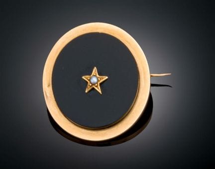 CIRCULAR GOLD BROOCH WITH ONYX AND A PEARL
A circu