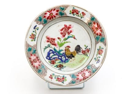 印度公司（又称“公鸡”）出品的瓷盘，饰有“玫瑰色系”多色彩绘，盘心描绘了一只置身花卉景观中的公鸡， 