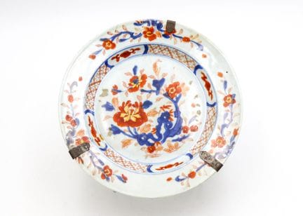 印度公司出品的釉面瓷盘，饰有蓝、红、金三色的伊万里纹样，点缀着花束及风格化的花卉图案
中国，18世纪