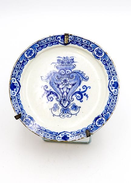 蓝白彩釉陶盘，盘心饰有风格化的花瓶图案，盘缘饰有几何图案带
代尔夫特，18世纪
直径 23 厘米 
